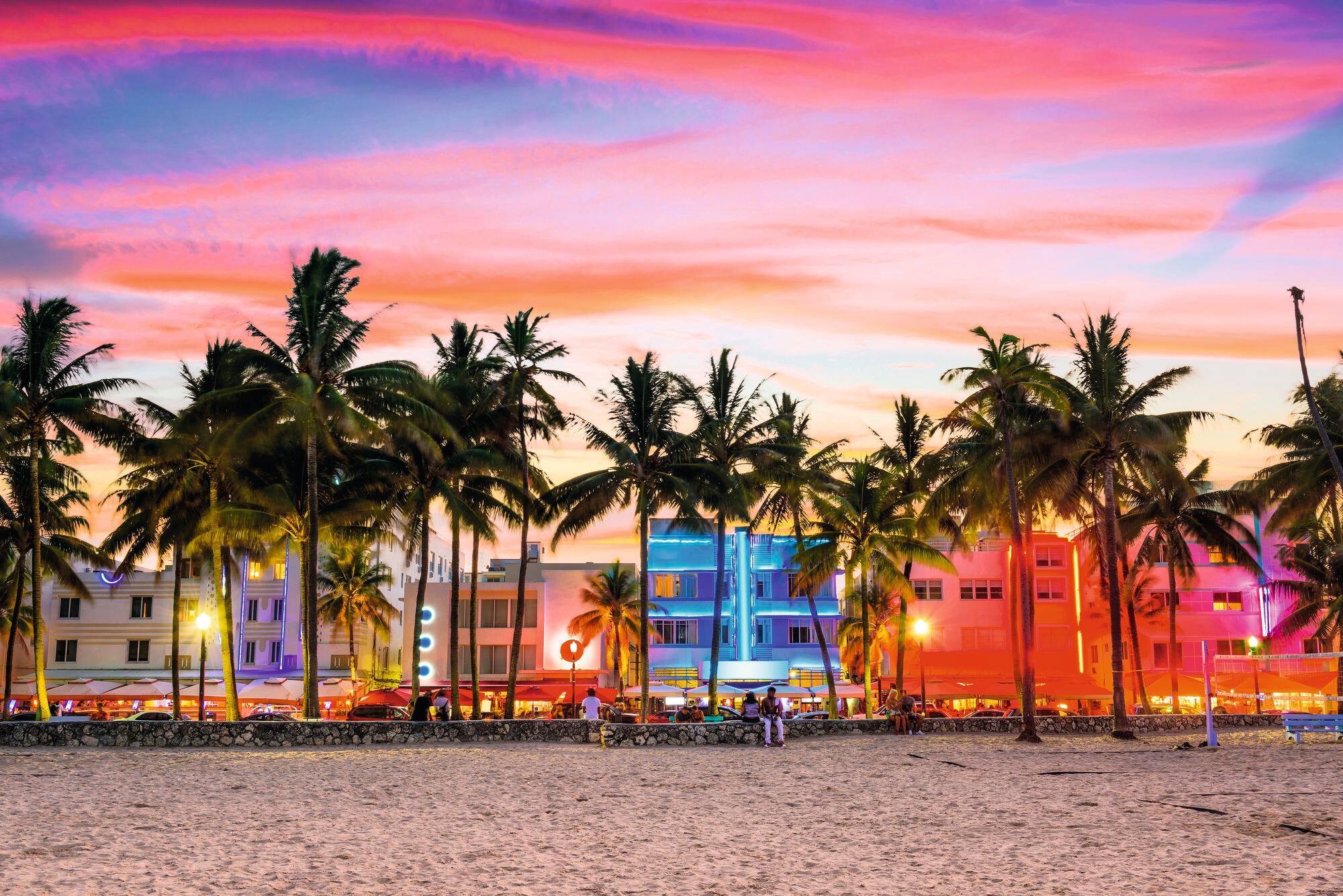 Miami South Beach at sunset, one of the most cool places to visit in USA with palm trees and colorful skyline.